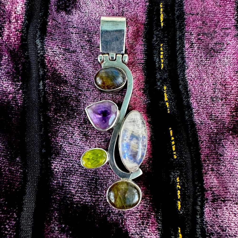 Sterling silver pendant with 5 gems in it. Beautiful & in excellent condition.